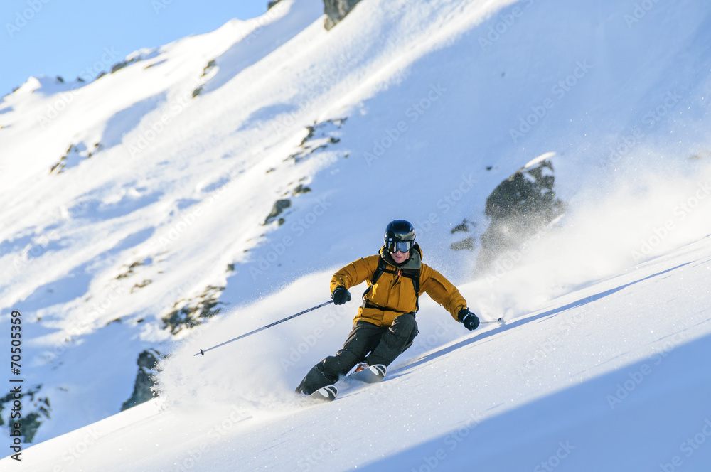 Skifahrer in Schnee-Staubwolke