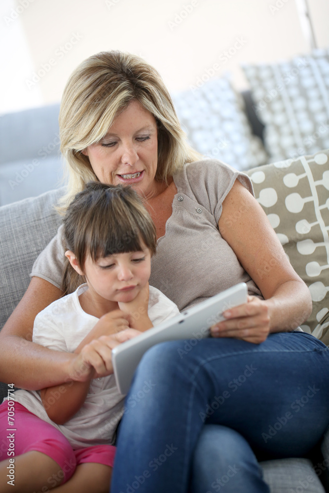 Mother and daughter playing games on tablet