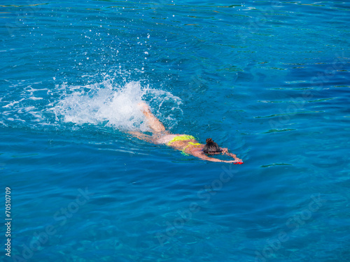 Beautiful girl swimming in blue water