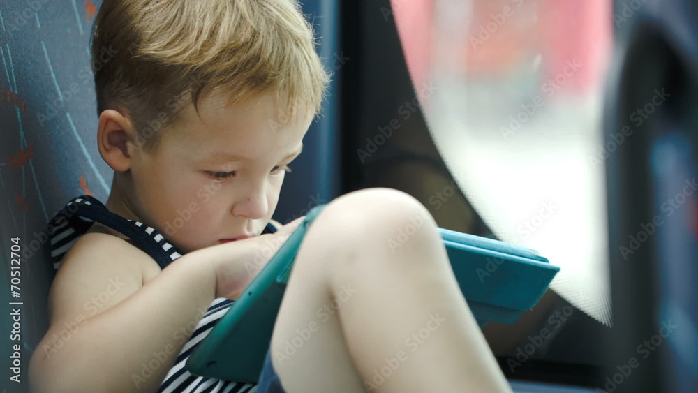 Little boy in car using tablet computer Little boy in car using tablet computer