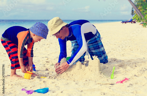 father and son building sand castle on beach © nadezhda1906