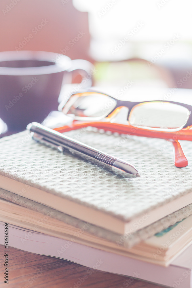 Pen and eyeglasses on three notebooks in coffee shop Pen and eyeglasses on three notebooks in coffee shop