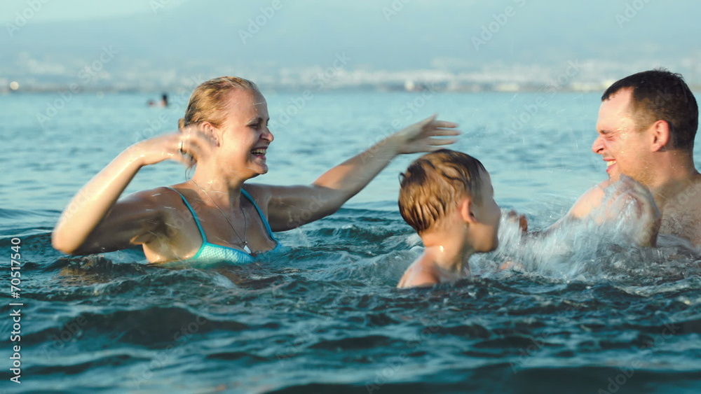 Happy family having fun in sea water Happy family having fun in sea water