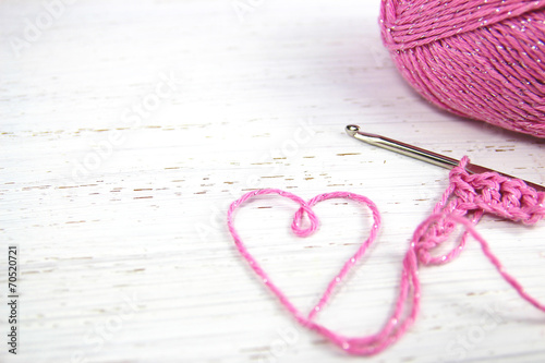 pink crochet background with yarn heart photo