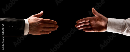 Two men reaching out to shake hands photo