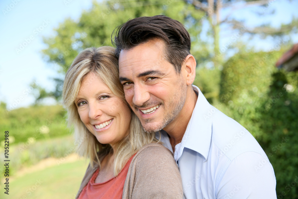 Portrait of happy mature couple in backyard