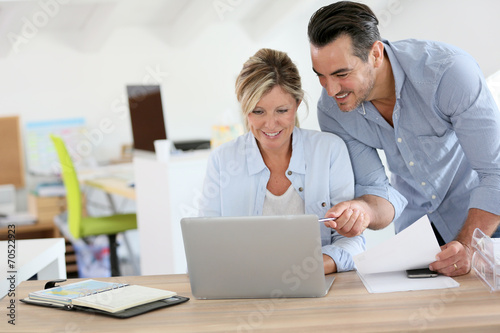 Business people working in office on laptop
