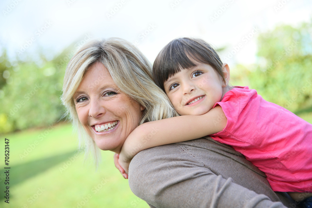 Mother giving piggyback ride to little girl Mother giving piggyback ride to little girl