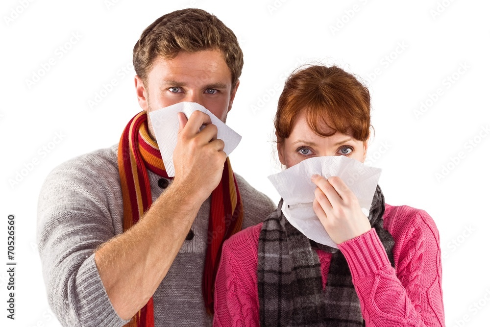 Couple blowing noses into tissues Couple blowing noses into tissues