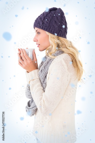 Pretty blonde in winter fashion holding mug
