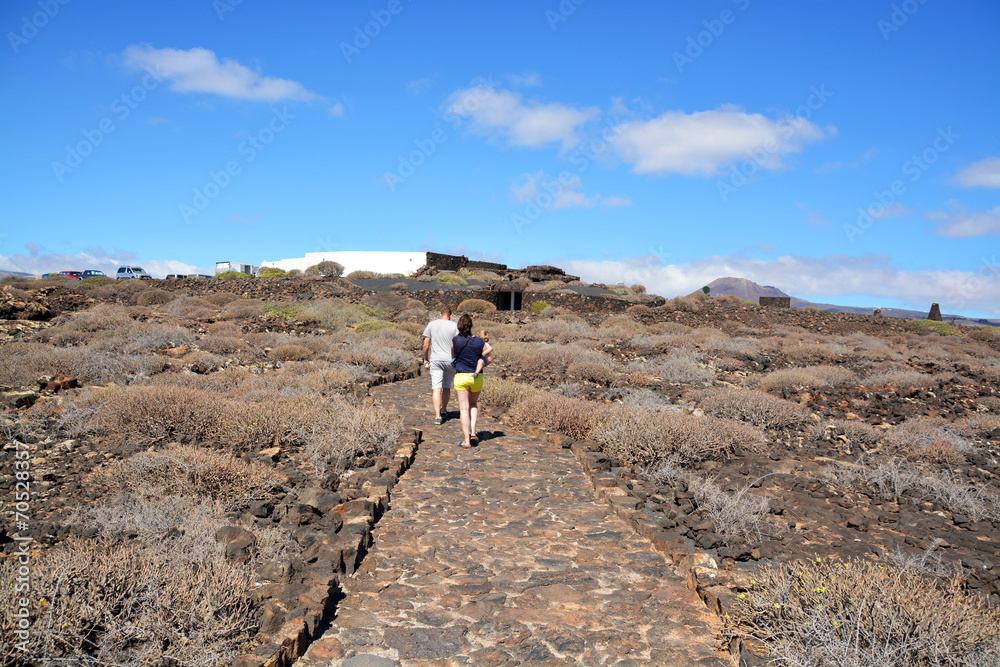 Obraz premium familia caminando por un camino de piedras en lanzarote