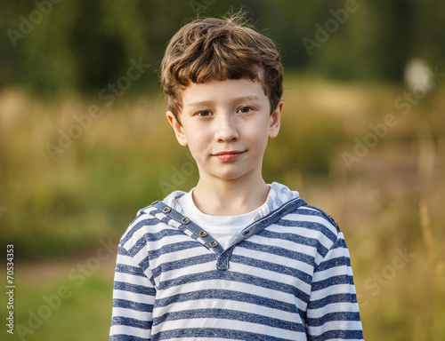 Cute young boy staying on the field