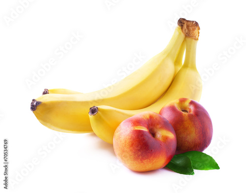 Ripe bananas and peaches on white.