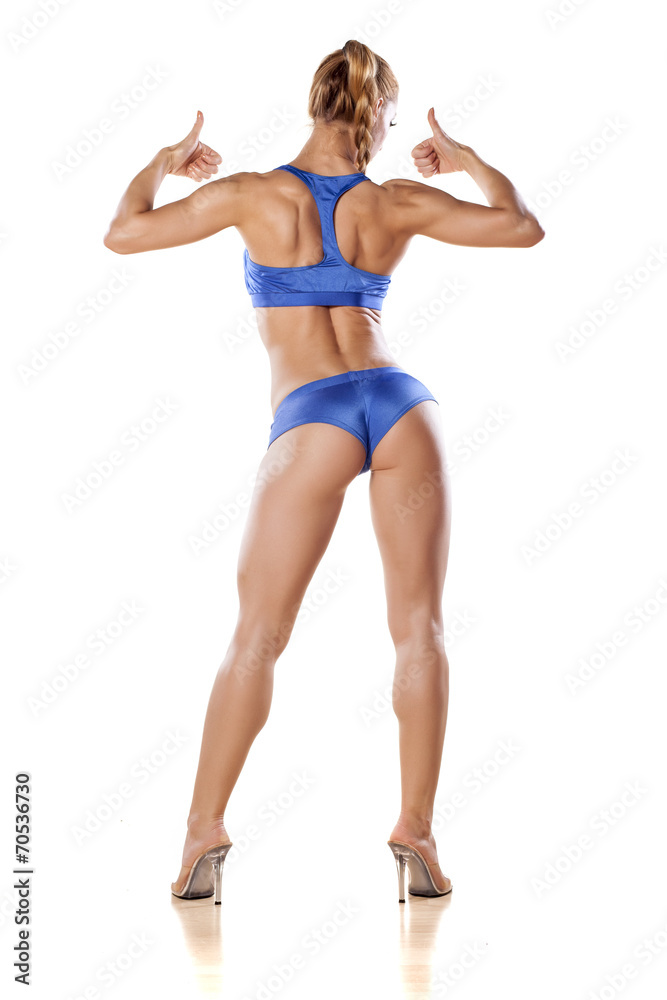 rear view of a muscular women posing and shows the thumb up