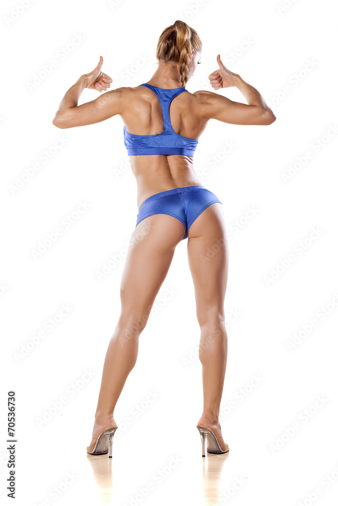 rear view of a muscular women posing and shows the thumb up rear view of a muscular women posing and shows the thumb up
