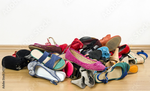 Big pile of woman shoes.Untidy stack of shoes thrown on floor.