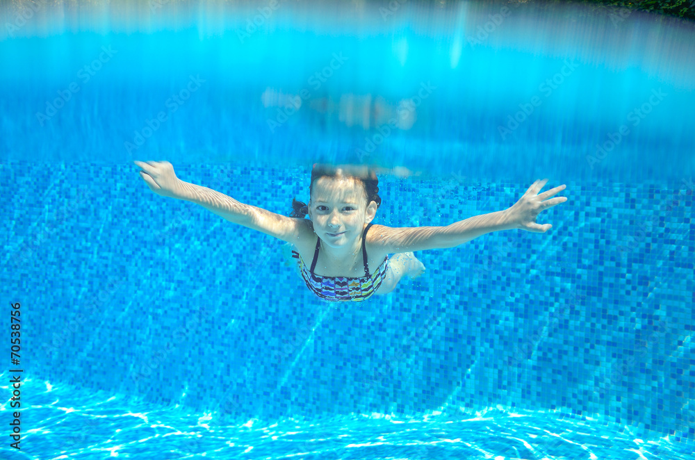 Happy active underwater child swims in pool, kids sport