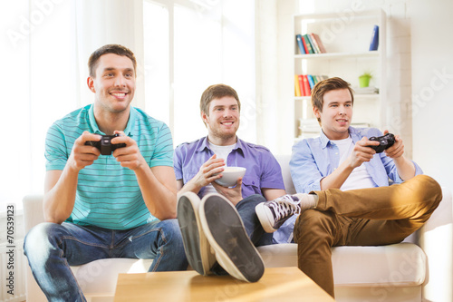 smiling friends playing video games at home