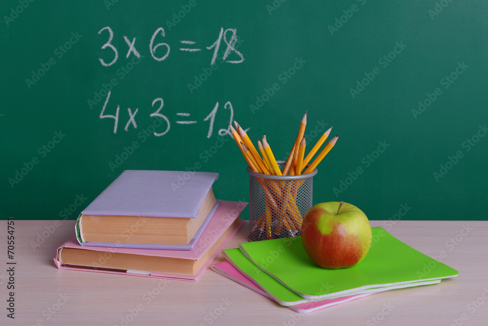 School supplies on table on board background School supplies on table on board background