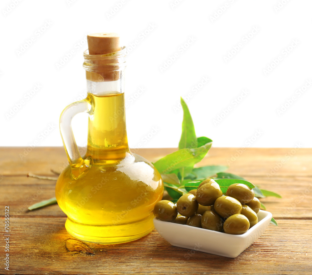 Green olives in bowl with leaves on table close-up Green olives in bowl with leaves on table close-up