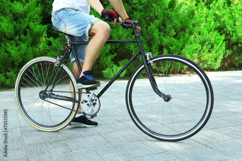 Young man riding bike in city park