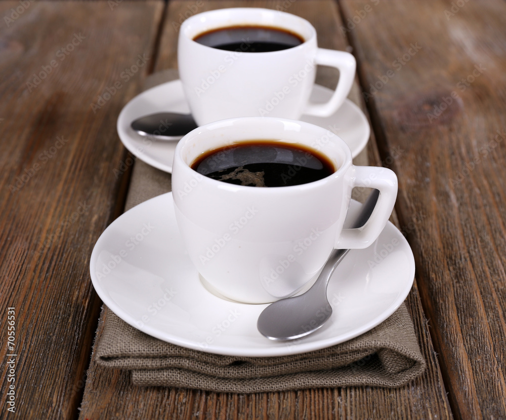Two cups of coffee on sackcloth napkin on wooden background Two cups of coffee on sackcloth napkin on wooden background