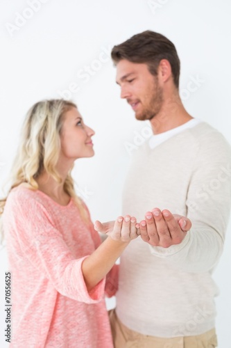 Attractive young couple holding out palms