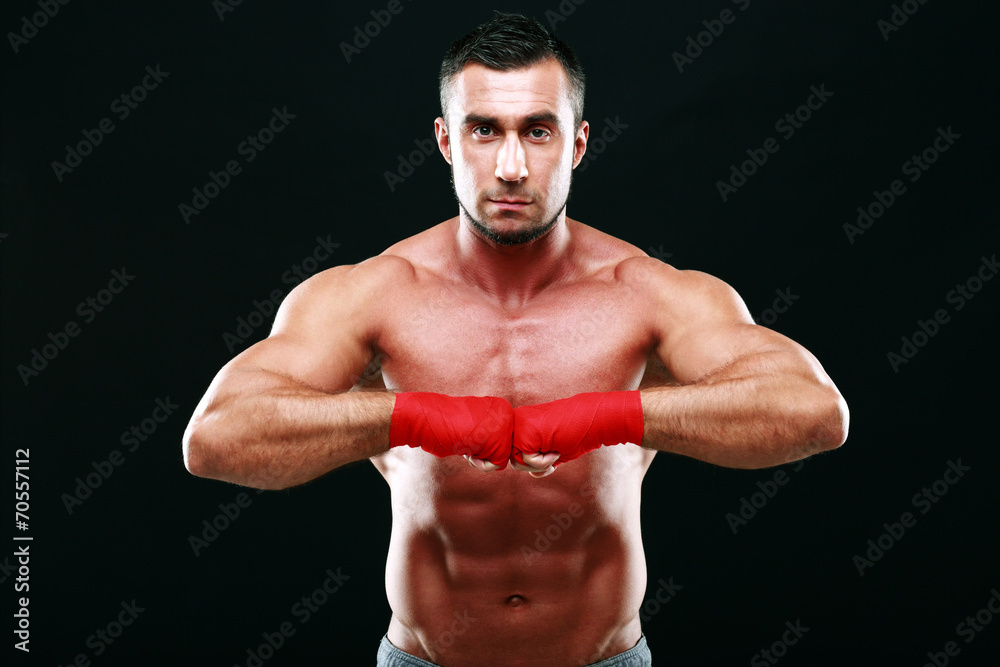 Portrait of a muscular man in red gloves on a black background