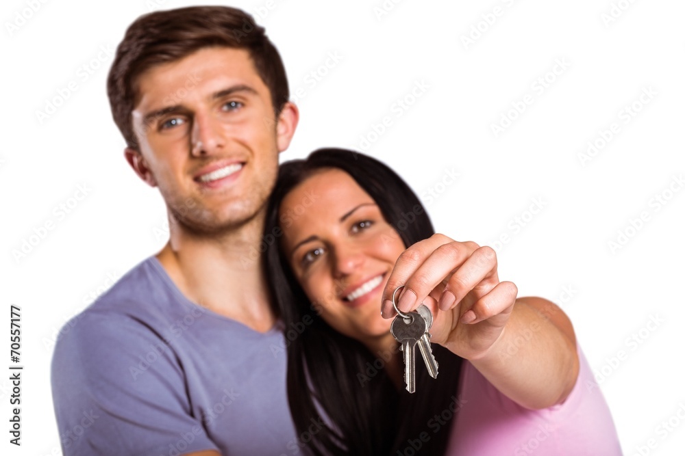 Young couple showing keys to house Young couple showing keys to house