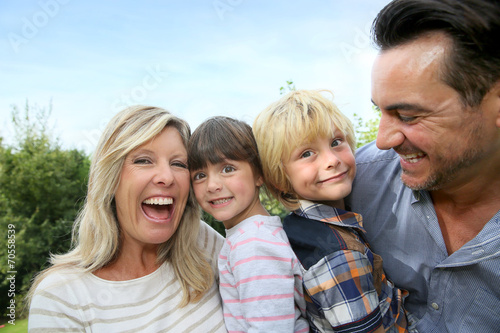 Happy family of four having fun outside
