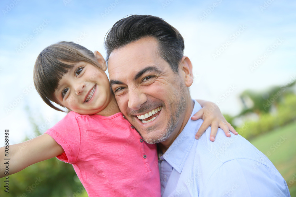 Obraz premium Portrait of little girl hugging her daddy