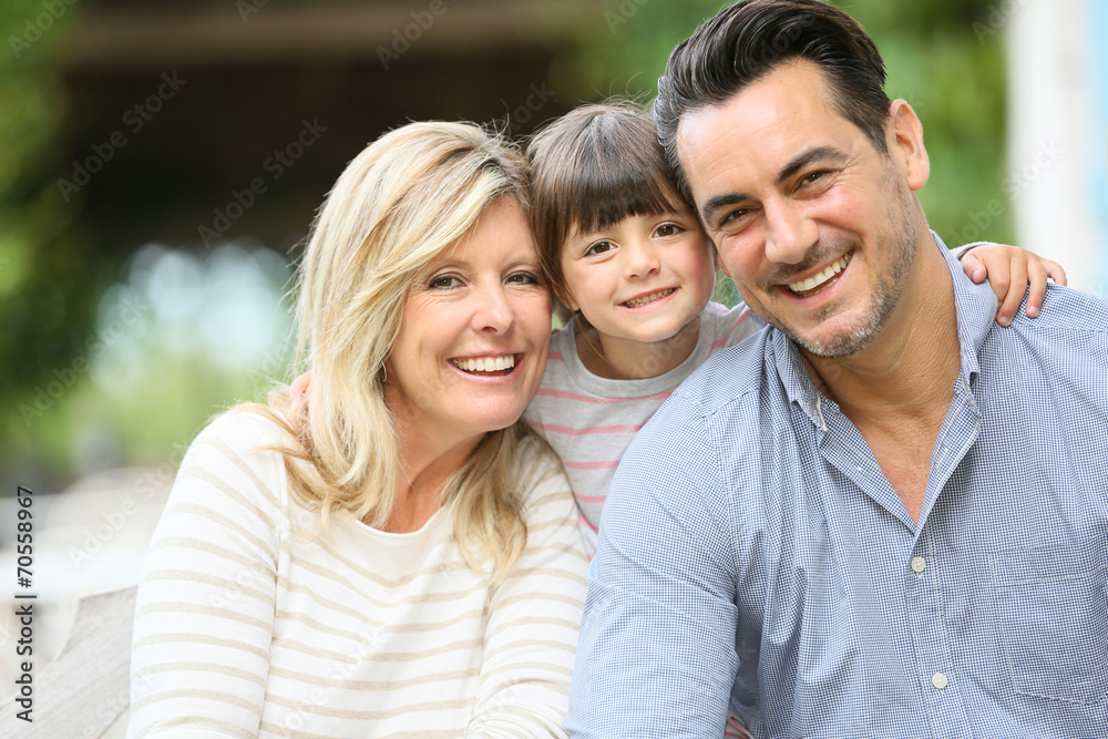 Portrait of parents with daughter sitting outside Portrait of parents with daughter sitting outside