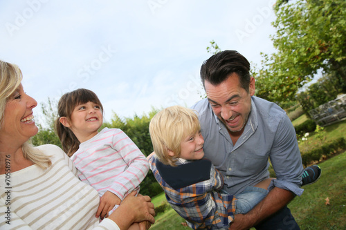 Happy family of four having fun outside © goodluz