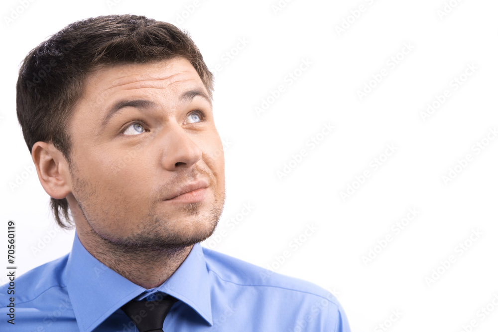 Handsome smiling young man looking up over white background.
