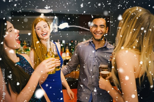 Composite image of laughing friends drinking beers