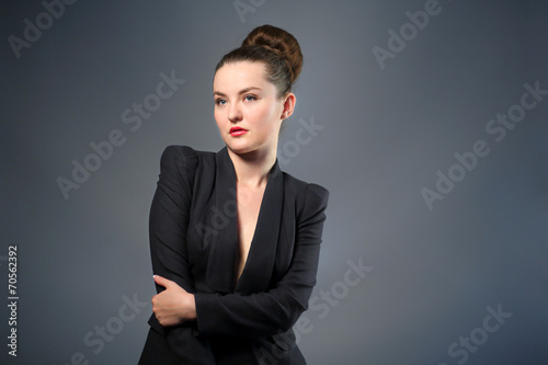 woman in black jacket stands quietly with her hands clasped photo