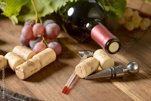 Stopper  with wine corks and bottle of wine on wooden