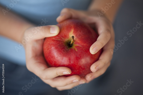 Child's hands holding a red apple