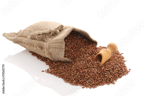 grade brown rice grain "devzira" scattered near the sack on a wh