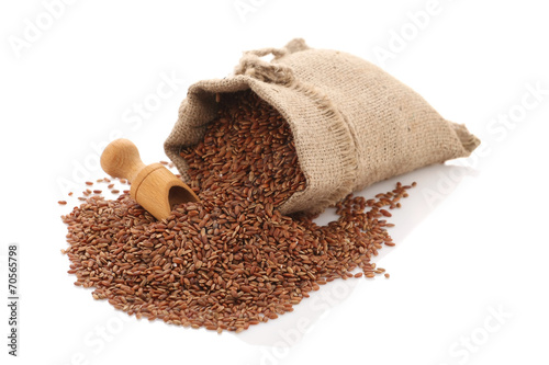 grade brown rice grain "devzira" scattered near the sack on a wh