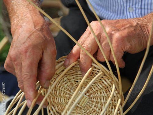 hands of skilled craftsman make a wicker basket photo