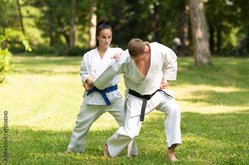 Two martial arts fighters practicing in nature.
