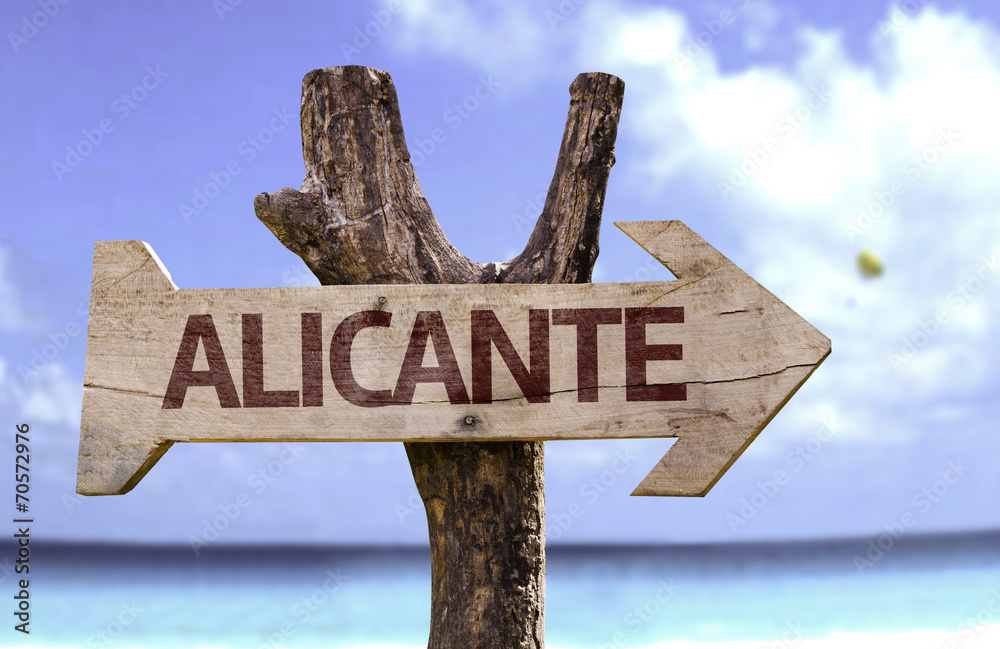 Alicante wooden sign with a beach on background