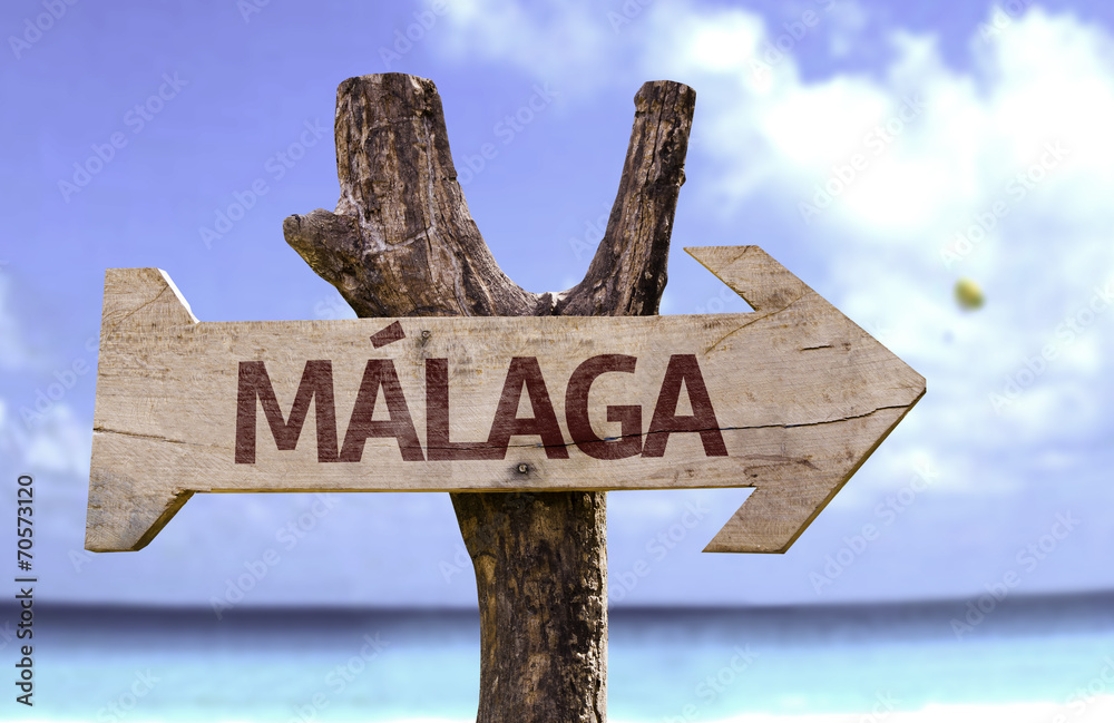 Malaga wooden sign with a beach on background