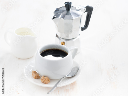 cup of black coffee, fresh cream and coffeemaker