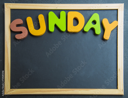 Colorful wooden word Sunday on black board