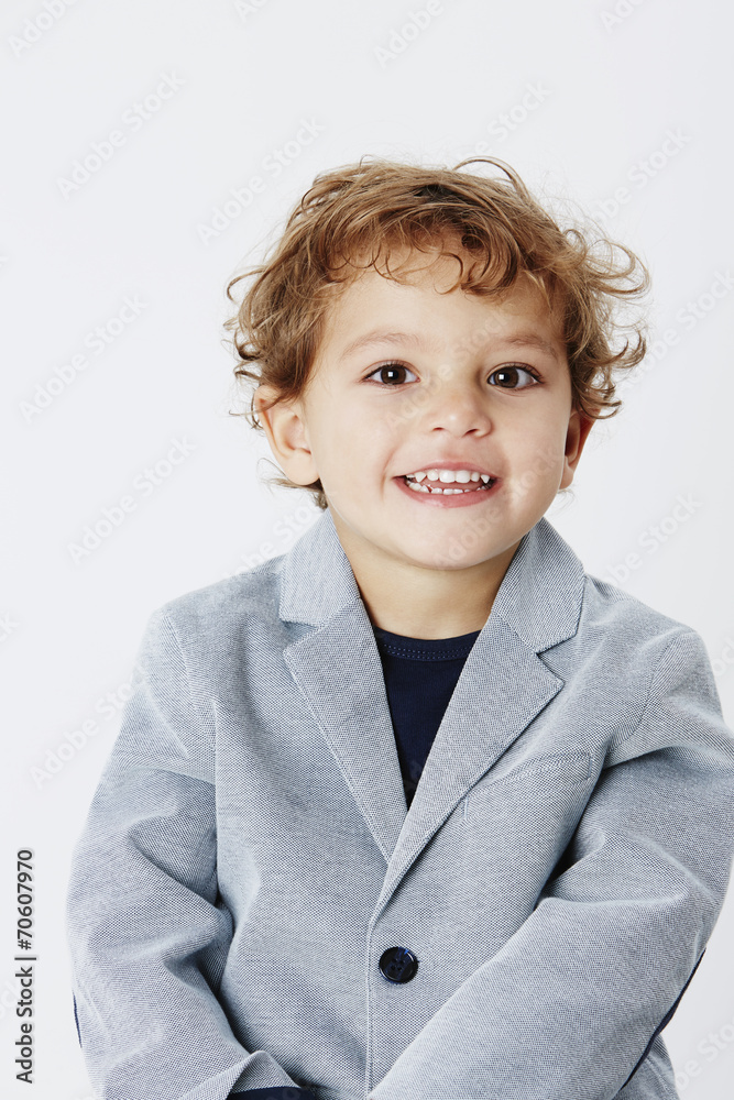 Smart and smiling young boy in suit jacket, portrait.