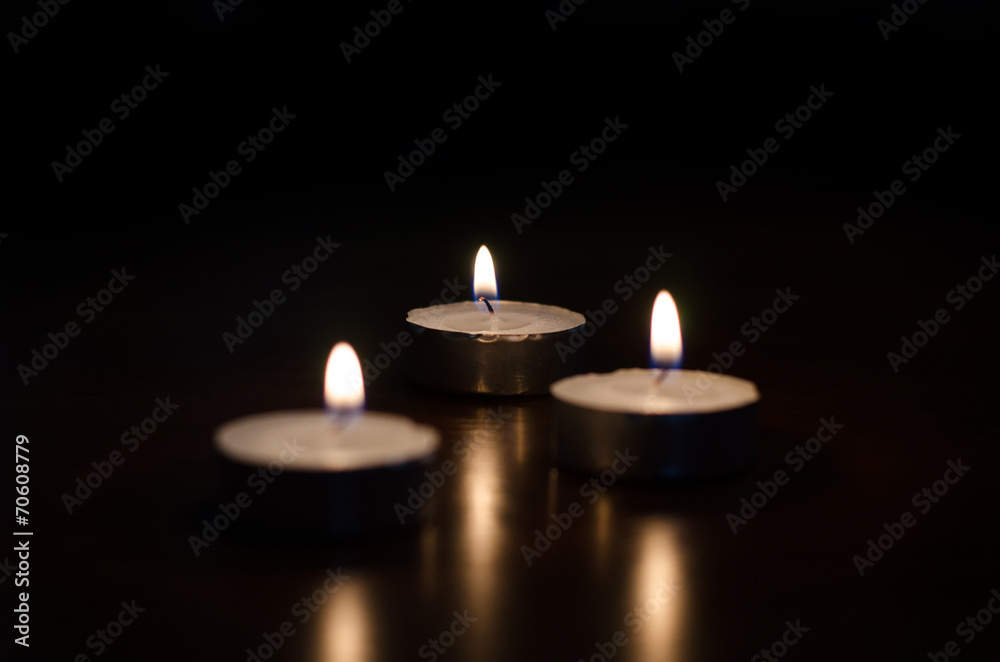 Three burning candles on black background Three burning candles on black background