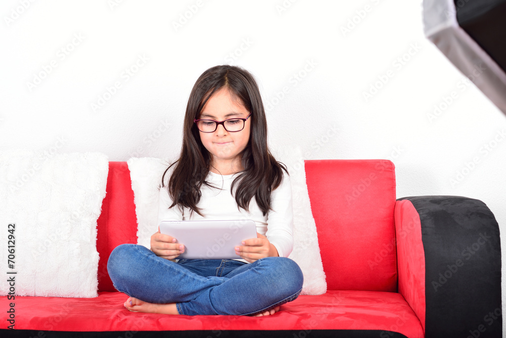 Little cute schoolgirl with a Tablet PC in a photo studio Little cute schoolgirl with a Tablet PC in a photo studio