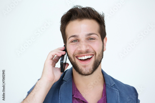 Cool young man smiling with mobile phone on white background